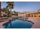 Stunning backyard pool with rock features and view of the home's exterior and putting green at 9128 N 70Th St, Paradise Valley, AZ 85253