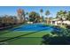Full tennis court with basketball hoop and lights, surrounded by mature landscaping at 9128 N 70Th St, Paradise Valley, AZ 85253