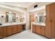 A spacious bathroom featuring dual vanities with wood cabinets and great lighting at 10002 E Adele Ct, Scottsdale, AZ 85255