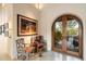 Charming entryway featuring arched doorway, natural light, and cozy seating area with nature views at 10002 E Adele Ct, Scottsdale, AZ 85255