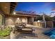 An outdoor kitchen, dining and lounge area complete with built-in grill and desert views by the pool at 10002 E Adele Ct, Scottsdale, AZ 85255