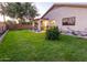 Spacious backyard with green lawn, mature trees, and a covered patio for outdoor enjoyment at 11197 W Coronado Rd, Avondale, AZ 85392