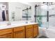 Bathroom with double sink vanity, large mirror, and tub with glass shower doors at 11197 W Coronado Rd, Avondale, AZ 85392