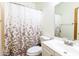 Clean bathroom featuring a white vanity, toilet, mirror, and shower with a decorative floral curtain at 11197 W Coronado Rd, Avondale, AZ 85392