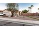 Charming single-story home featuring a well-manicured yard, mature trees, desert landscaping, and a unique water fountain at 11197 W Coronado Rd, Avondale, AZ 85392