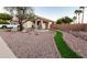 Landscaped front yard featuring desert landscaping, artificial turf, mature trees, and a beautiful tiered fountain at 11197 W Coronado Rd, Avondale, AZ 85392