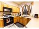 Functional kitchen with oak cabinets, laminate countertops, a gas range, and a stainless steel sink at 11197 W Coronado Rd, Avondale, AZ 85392