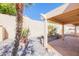 Secluded backyard with a covered patio, decorative rock landscaping, palm trees, and desert plants at 12224 N Gambel Dr, Fountain Hills, AZ 85268