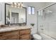 Well-lit bathroom featuring modern fixtures, granite countertops, and a shower-tub combo with glass doors at 1411 E Orangewood Ave # 202, Phoenix, AZ 85020