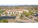 Beautiful clubhouse featuring red tile roof, lush landscaping, and circular driveway at 15305 S 180Th Ave, Goodyear, AZ 85338