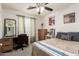 Bedroom featuring a desk, ceiling fan, closet, and natural light at 16350 N Desert Sage St, Surprise, AZ 85378