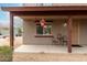 Relax on the covered porch with cozy seating, perfect for enjoying a quiet morning at 16350 N Desert Sage St, Surprise, AZ 85378