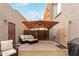 Cozy outdoor patio featuring comfortable seating under a large umbrella, perfect for relaxing and entertaining at 16350 N Desert Sage St, Surprise, AZ 85378