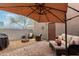 Secluded patio with seating area, fire pit, and shade umbrella, creating an ideal outdoor living space at 16350 N Desert Sage St, Surprise, AZ 85378