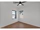 Cozy bedroom featuring vinyl flooring, two large windows, and a modern ceiling fan at 18053 W Rimrock St, Surprise, AZ 85388