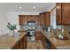 Bright kitchen with granite countertops, wood cabinets, stainless steel appliances, and a view from the window at 18053 W Rimrock St, Surprise, AZ 85388