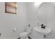 Simple powder room featuring a pedestal sink, toilet, and small window providing natural light at 18053 W Rimrock St, Surprise, AZ 85388