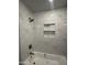 Stylish bathroom featuring tub with tiled surround and convenient inset shelving at 18626 N 28Th Way, Phoenix, AZ 85050