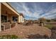 Expansive back patio offers a stunning view, complemented by a charming outdoor dining area and lush landscaping at 19839 N 267Th Ave, Buckeye, AZ 85396