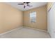A simple bedroom with beige walls, carpeting, and a ceiling fan at 20821 W Ridge Rd, Buckeye, AZ 85396