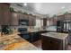 Well-equipped kitchen with granite countertops, dark wood cabinets, and black appliances at 20821 W Ridge Rd, Buckeye, AZ 85396