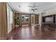 A spacious living room with wood floors, a ceiling fan, and a built-in entertainment center at 20821 W Ridge Rd, Buckeye, AZ 85396