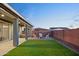 Expansive backyard with artificial grass, a covered patio, a spa, and a fire pit area at 23282 S 229Th Pl, Queen Creek, AZ 85142