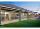 Wide angle of landscaped backyard with turf, patio with dining, and hot tub ready for relaxation at 23282 S 229Th Pl, Queen Creek, AZ 85142