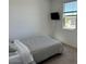 A bedroom featuring a striped bedspread, mounted TV, and natural light from the window at 23282 S 229Th Pl, Queen Creek, AZ 85142