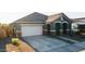 Charming home featuring a two-car garage, stone pillar accents, and manicured landscaping, enhancing curb appeal at 23282 S 229Th Pl, Queen Creek, AZ 85142