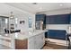 Bright kitchen features navy cabinets, stainless steel appliances, quartz countertops, and an island with seating at 23282 S 229Th Pl, Queen Creek, AZ 85142