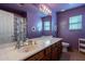 Purple bathroom with a vanity with a large mirror, sink and toilet at 2528 W Mericrest Way, San Tan Valley, AZ 85144