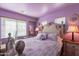 Cozy bedroom features a decorative bed frame, purple walls and bedside tables at 2528 W Mericrest Way, San Tan Valley, AZ 85144