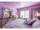 Comfortable bedroom featuring a decorative bed frame, mirrored dresser and purple walls at 2528 W Mericrest Way, San Tan Valley, AZ 85144