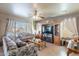 Open living room with ceiling fan, large TV, and access to patio and outdoor area at 2528 W Mericrest Way, San Tan Valley, AZ 85144