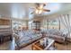 Spacious living room with large windows, ceiling fan, and floral pattern couches provides serene interior living at 2528 W Mericrest Way, San Tan Valley, AZ 85144