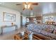 Cozy living room featuring floral couches, tile floors, and open layout to kitchen and dining areas at 2528 W Mericrest Way, San Tan Valley, AZ 85144