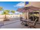 Cozy backyard patio with umbrella-covered seating and view of a refreshing swimming pool at 2528 W Mericrest Way, San Tan Valley, AZ 85144