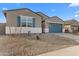 Charming single-story home featuring a blue garage door and desert landscaping at 37053 W La Paz St, Maricopa, AZ 85138