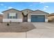 Charming single-story home featuring a blue garage door and desert landscaping at 37053 W La Paz St, Maricopa, AZ 85138