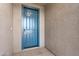 Stylish blue front door with modern hardware and neutral textured walls at 37053 W La Paz St, Maricopa, AZ 85138