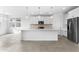 Bright, open kitchen featuring white cabinetry, stainless steel appliances, and a large center island at 37053 W La Paz St, Maricopa, AZ 85138