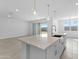Kitchen island with quartz countertop and pendant lighting in an open concept living space at 37053 W La Paz St, Maricopa, AZ 85138