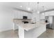 Modern kitchen features white cabinets, stainless steel appliances, and a large center island with pendant lighting at 37053 W La Paz St, Maricopa, AZ 85138