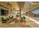 Spacious covered patio featuring ceiling fans, comfortable seating, and travertine tile flooring at 41908 N La Cantera Dr, Anthem, AZ 85086