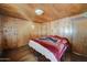 Wood-paneled bedroom featuring a bed with a patterned blanket at 4302 W Dobbins Rd, Laveen, AZ 85339