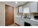 Simple kitchen featuring white cabinets and a sink, illuminated by a window at 4302 W Dobbins Rd, Laveen, AZ 85339