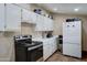 Functional kitchen with white cabinets, black range, and stainless steel appliances at 4302 W Dobbins Rd, Laveen, AZ 85339