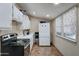 Efficient kitchen with appliances, white cabinets, and a window at 4302 W Dobbins Rd, Laveen, AZ 85339