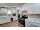 A bright kitchen featuring white cabinets, stainless steel appliances, and a window at 4302 W Dobbins Rd, Laveen, AZ 85339